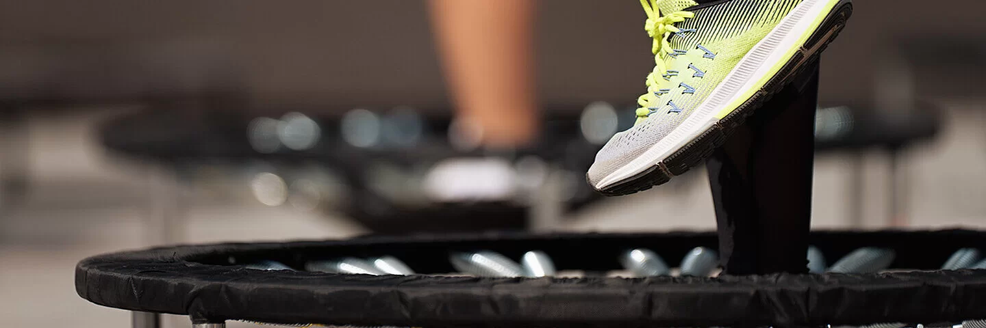 Zwei Menschen machen Jumping Fitness auf zwei Mini-Trampolins.