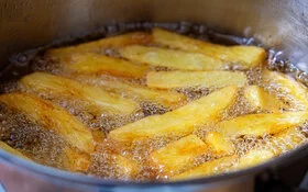 Pommes werden in Öl in einem Topf frittiert. Dabei entstehen Transfette.