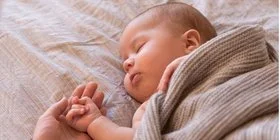 Baby liegt im Bett