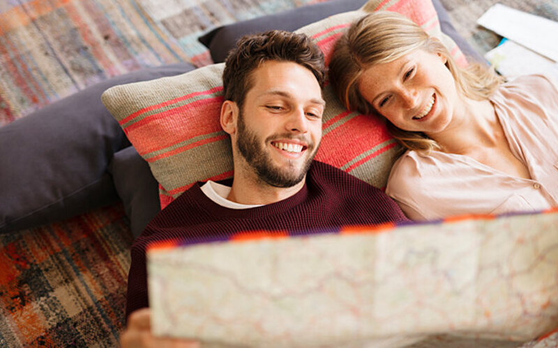 Ein junges Paar plant seine Reise, um im Urlaub bestmöglich zu entspannen.