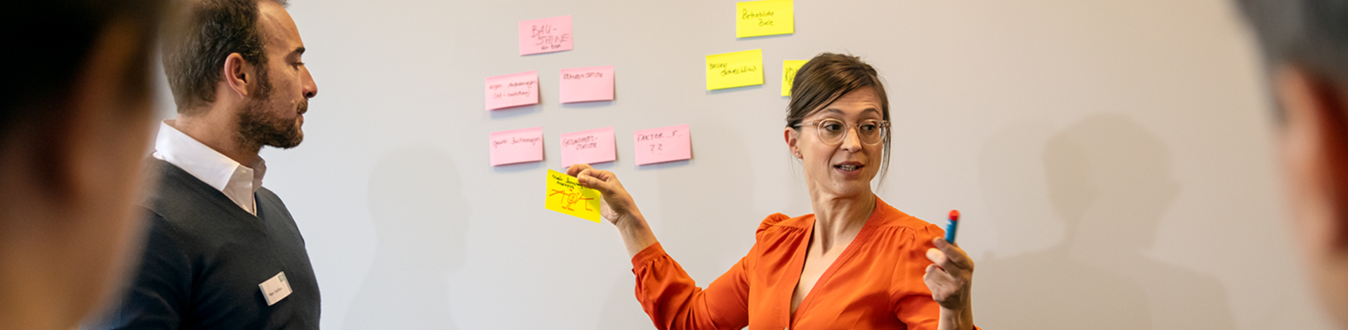 Eine Frau hält ein Post-It in der Hand.