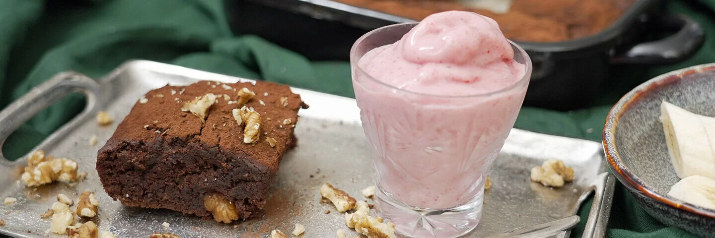 Brownies mit Banane, Datteln und Nicecreme, angerichtet auf einem grünen Tischtuch, zubereitet von Felicitas Then.