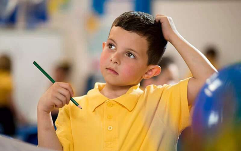 Ein Junge in der Grundschule denkt über den Unterrichtsstoff nach und ist unsicher.