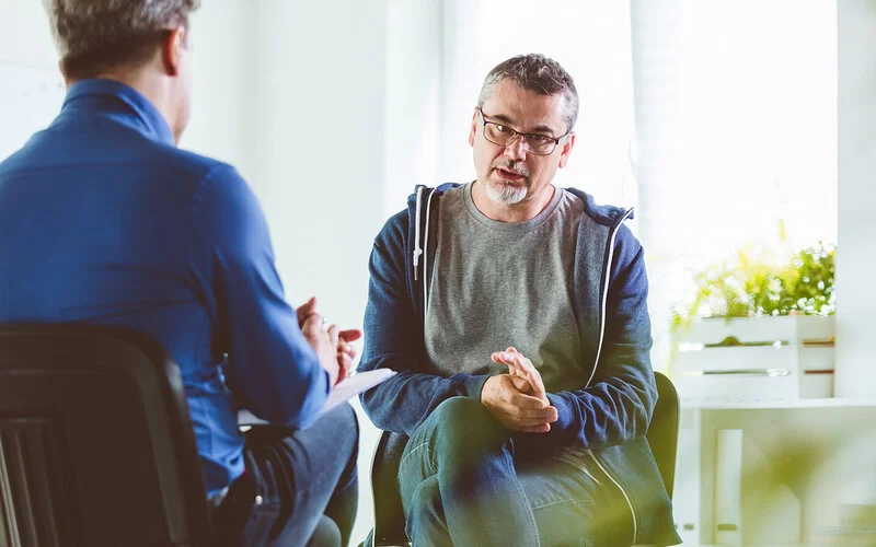 Ein Mann mit Depressionen bei einer Psychotherapie-Sitzung.