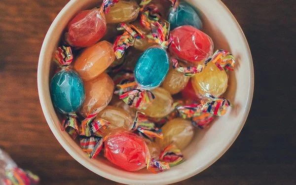 Eine Schüssel mit bunten Bonbons auf einem Holztisch