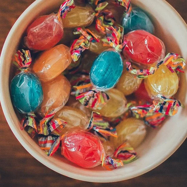 Eine Schüssel mit bunten Bonbons auf einem Holztisch