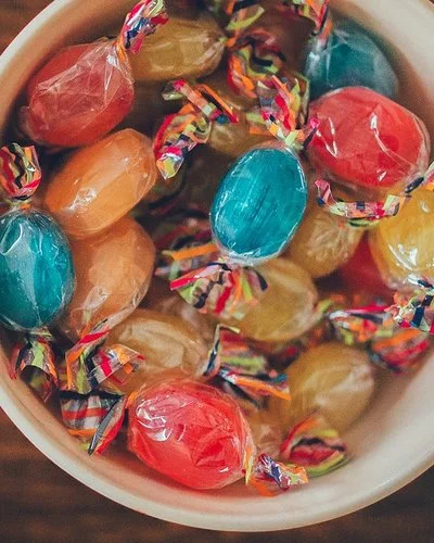 Eine Schüssel mit bunten Bonbons auf einem Holztisch