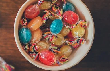 Eine Schüssel mit bunten Bonbons auf einem Holztisch