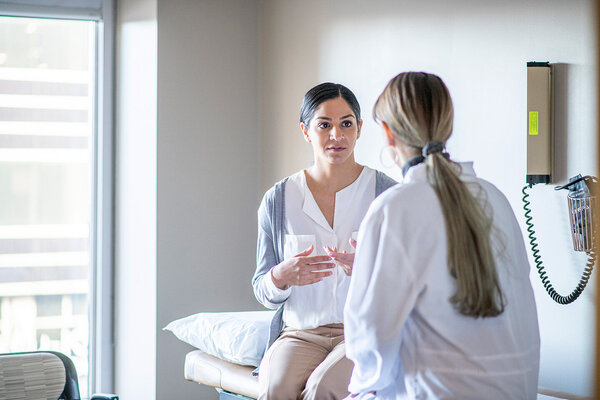 Eine junge Frau spricht mit einer Ärztin in einer Praxis über Notfallverhütung.