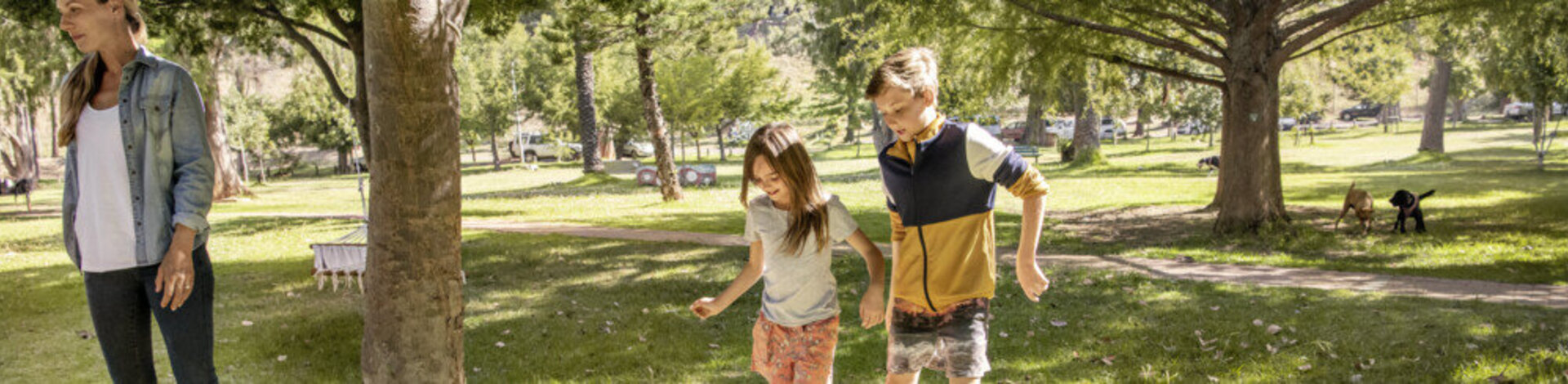 Mädchen und Junge spielen Fußball im Park. Mit dem AOK-Kinderbonus können sie bei der Teilnahme an Gesundheitskursen Punkte sammeln und eine Prämie erhalten.