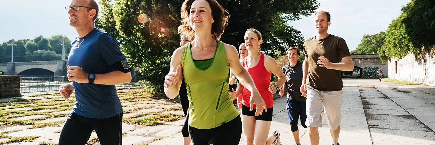 Frau macht Sport in einer Laufgruppe, um sich langfristig zum Sport zu motivieren.