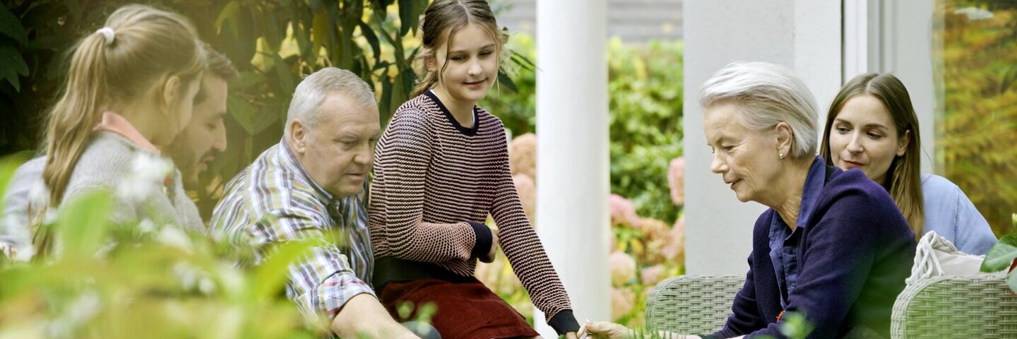Eine Familie bei Kaffee und Kuchen auf der Terrasse.