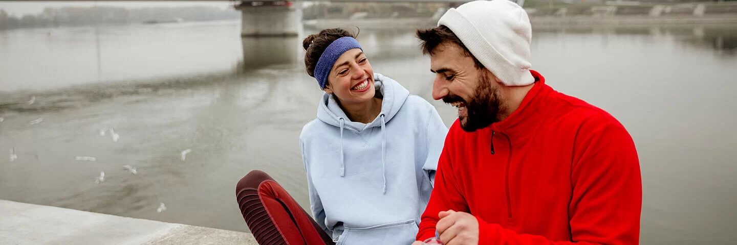 Zwei junge Menschen legen eine Joggingpause ein. 