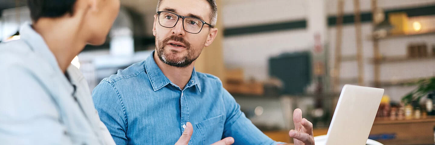 Ein Mann sagt zu seinem Chef im Job Nein, um auf sich selbst aufzupassen und Burnout vorzubeugen.