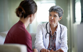 Eine Ärztin erklärt ihrer Patientin, dass sie an Darmkrebs erkrankt ist.