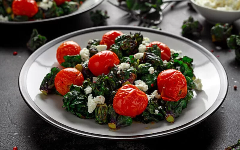 Ein selbst gemachter Kalettes-Salat mit Tomaten und Feta stehen auf dem Tisch.