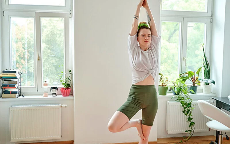 Junge Frau macht Entspannungsübungen, um Stress im Studium zu reduzieren.