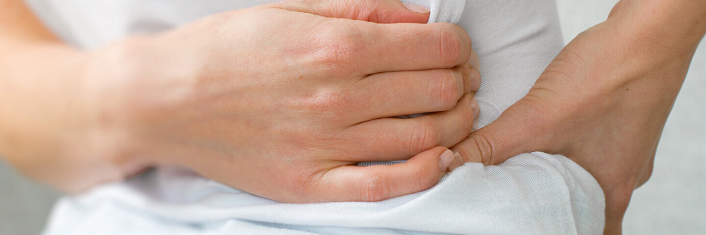 Nierensteine: Betroffener fasst sich an den Bauch und die Nieren