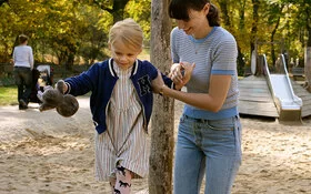 Loben- Mutter und Kind auf dem Spielplatz.