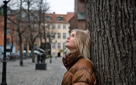 Hochsensible Frau blickt nach oben und beobachtet etwas.