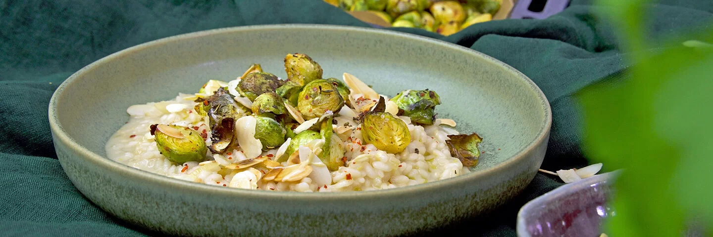 Risotto mit Zitrone und Rosenkohl, auf einem Teller angerichtet auf einem grünen Tischtuch, gekocht von Felicitas Then.