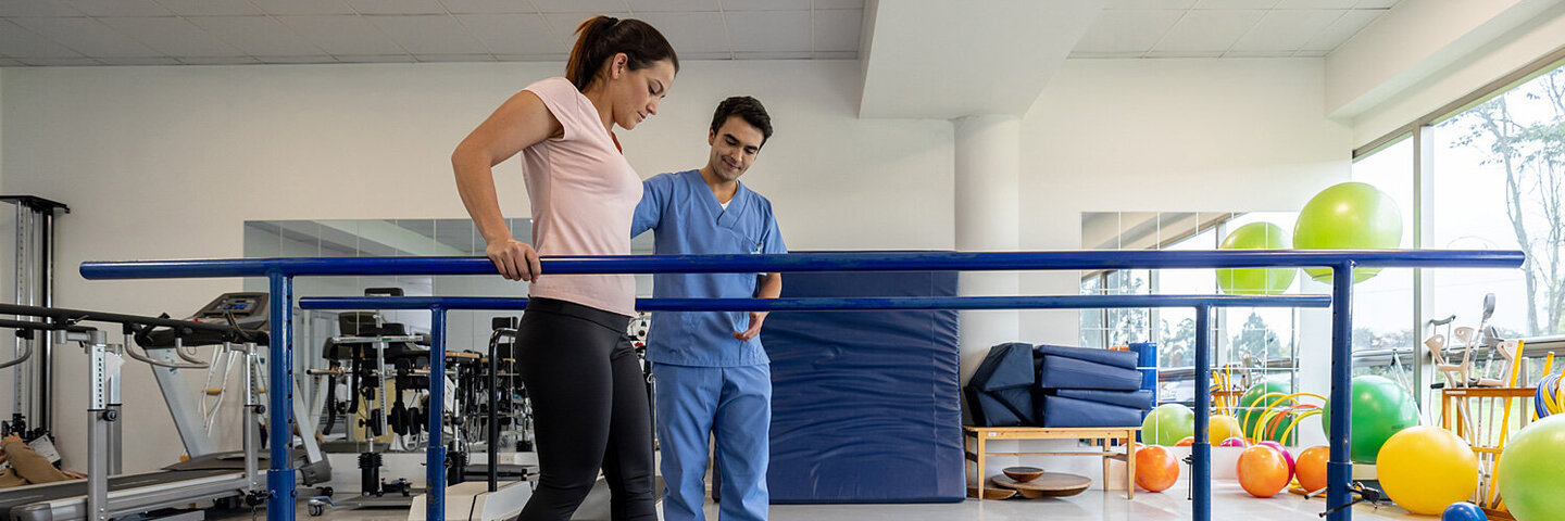 Frau absolviert ein kräftigenden Gehtraining bei einer Rehabilitationsmaßnahme.