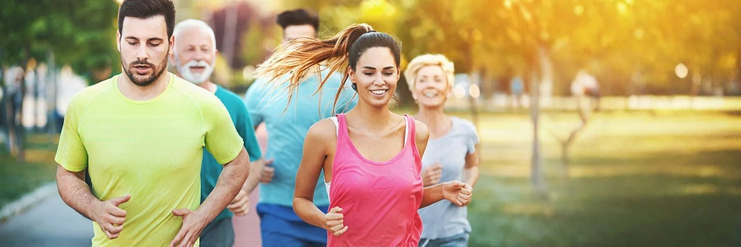 Ein Gruppe Sportler joggt im Park.