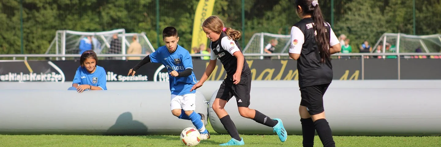 Eine Gruppe Kinder spielt Fussball.