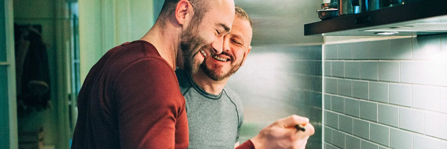 Zwei Männer kochen sich in der Küche ein gesundes veganes Essen.