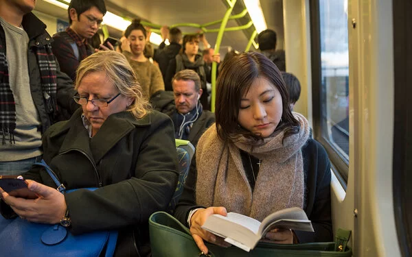 Viele Menschen sitzen und stehen eng an eng in einem Bus.