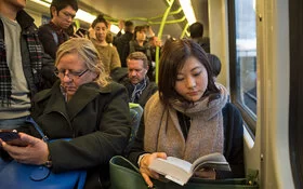 Viele Menschen sitzen und stehen eng an eng in einem Bus.