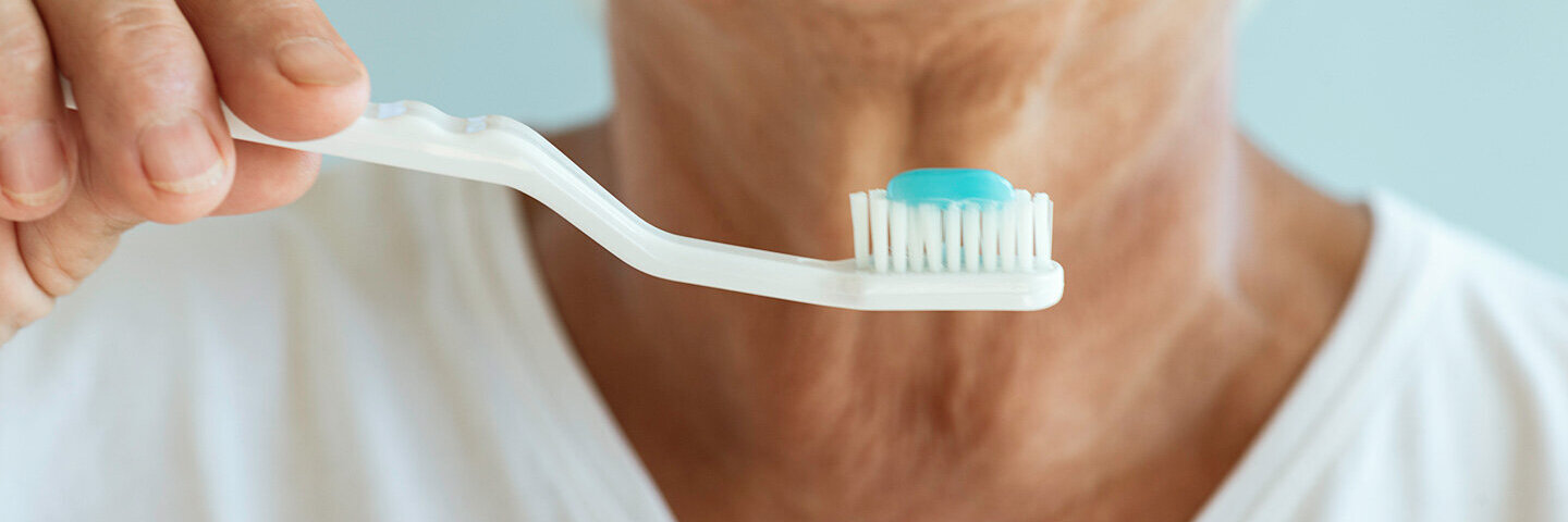 Ältere Dame bereitet sich aufs Zähneputzen vor – aber welche Zahnbürste ist die beste?