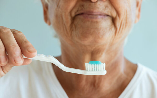 Ältere Dame bereitet sich aufs Zähneputzen vor – aber welche Zahnbürste ist die beste?