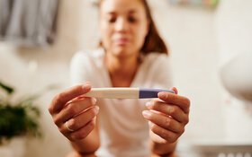 Eine Frau schaut auf einen Schwangerschaftstest.