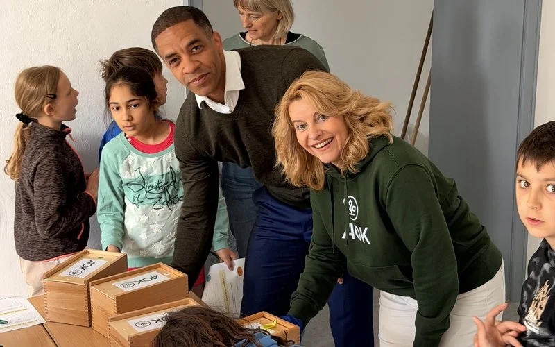 Kinder und AOK-Begleitung testen gemeinsam interaktive Gesundheitsstationen im Schulprojekt Ahorn@school zur Förderung von Bewegung und Teamarbeit.