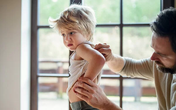 Kind mit Scharlach wird untersucht.