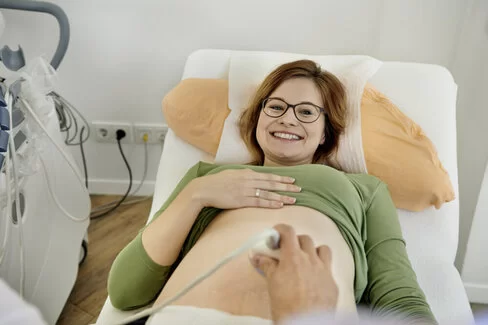 Ein Arzt untersucht eine werdende Mutter per Ultraschall.