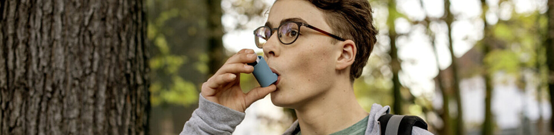 Ein Asthma-Patient ist im Freien und verwendet einen Inhalator. Erfahren Sie mehr über die Krankheit.