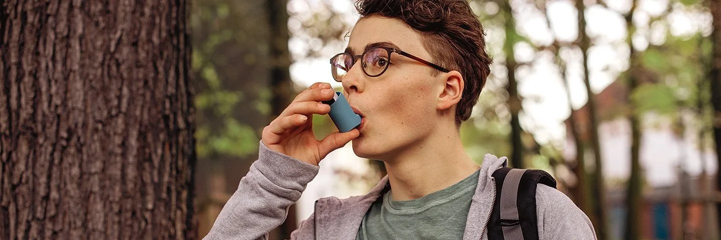 Ein Asthma-Patient ist im Freien und verwendet einen Inhalator. Erfahren Sie mehr über die Krankheit.