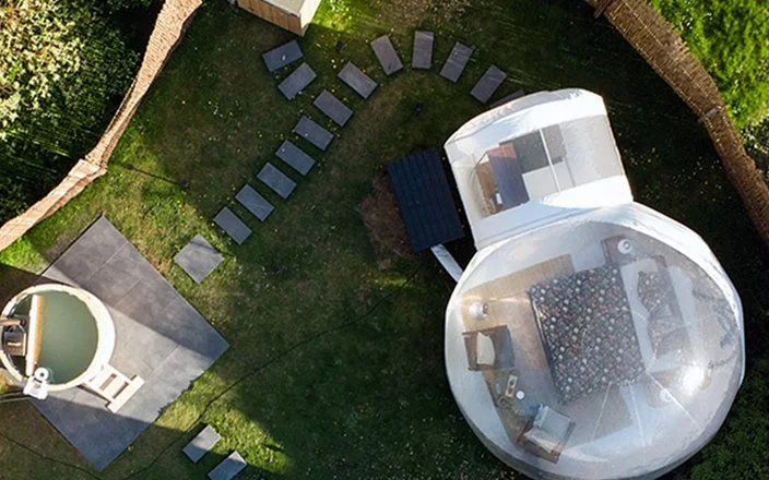 Luftaufnahme eines Bubble Tents und einem Whirlpool in einem Garten.