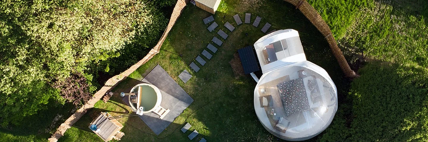 Luftaufnahme eines Bubble Tents und einem Whirlpool in einem Garten.