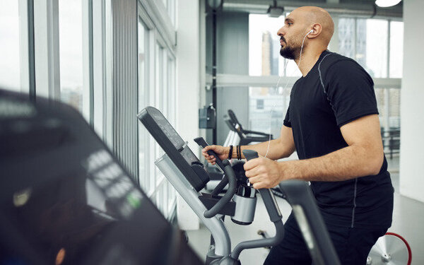 Mann treibt Sport im Fitnessstudio und geht seinem guten Vorsatz nach.