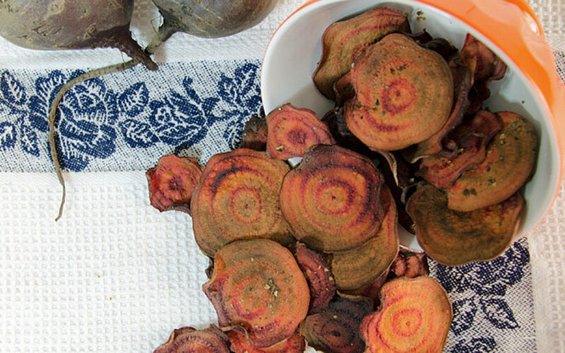 Rote Beete Knollen liegen neben selbst gebackenen Rote Beete Chips.