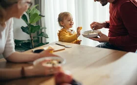 Vater reicht seinem Kleinkind gesundes Essen.