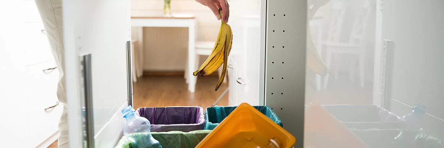 Eine Person überlegt, in welchen Müll die Bananenschale gehört.