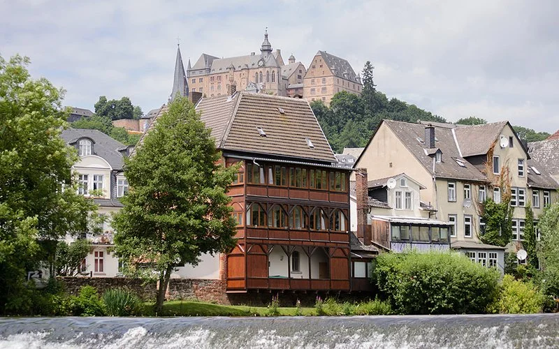 Das Marburger Schloss thront herrschaftlich auf dem Schlossberg, umgeben von den liebevoll restaurierten Fassaden mittelalterlicher Stadthäuser.
