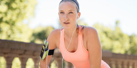 Eine Frau macht nach dem Joggen Dehnübungen. Das Onlineprogramm „Laufend in Form“ der AOK unterstützt sie beim Lauftraining.