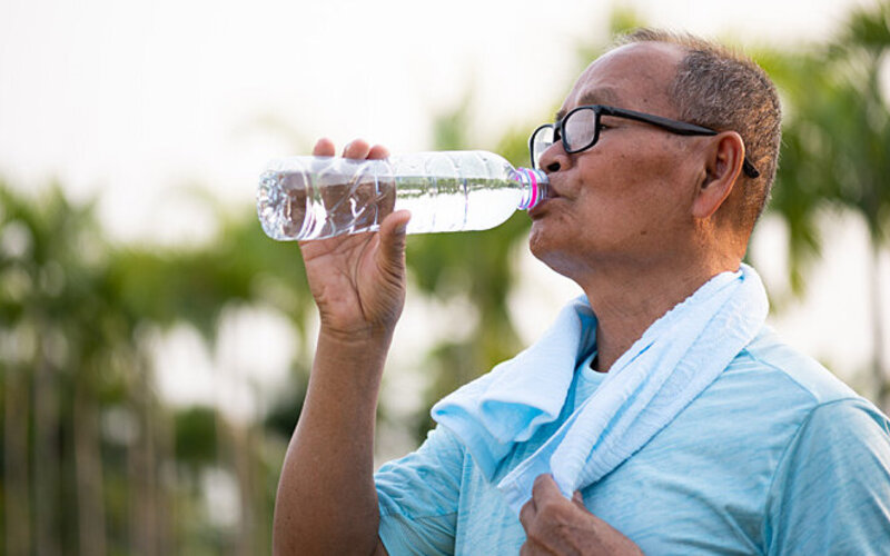 Ein älterer Mann trinkt Wasser