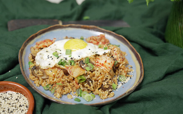 Fried Kimchi Rice mit Spiegeleiern auf einem Teller serviert.