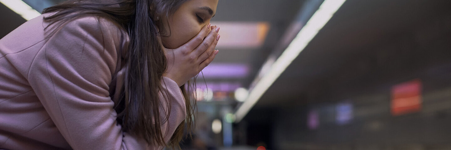 Junge Frau hat eine Panikattacke in einer unterirdischen Bahnstation.